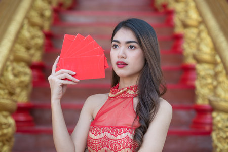 Young happy Asian woman wear cheongsam holding red envelopes in Chinese New Yearの写真素材