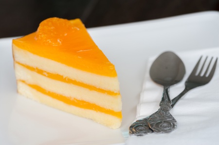 Orange cake on white dish at coffee shopの写真素材