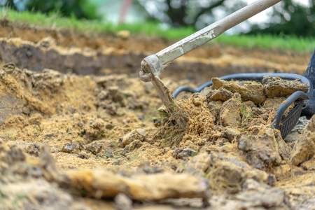 gardener digs the soil with his equipment for gardening and prepare land for plantation.
