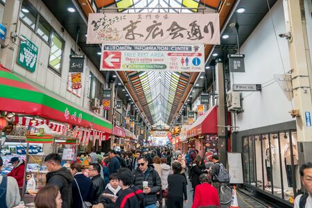 Osaka, Japan - 3 Mar 2018; Japanese local people, tourists and travelers walking and eating at Kuromon Ichiba Market (fish market), Osaka, Japan.のeditorial素材