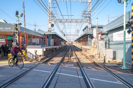 Kyoto, Japan - 2 Mar 2018: Local Japanese and tourists waiting train across the street on the way to Fushimi Inari  Shrine on 2 Mar 2018, Kyoto, Japan.のeditorial素材
