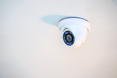 white CCTV camera hang on to the ceiling.の写真素材
