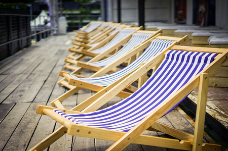 Navy line on canvas chairs with old wood terrace.