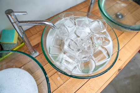 a lot of a glass of water glass in the glass sink ready for washing and clean.の写真素材