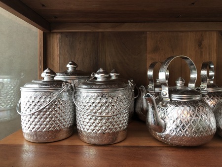 Thai silver vintage pot and kettle, in the wooden kitten storage.