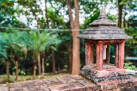 the integrated Fluorescent and ancient vintage cement lamp (pavilion style) on brick wall in the forest, Chiangmai, Thailand.の写真素材