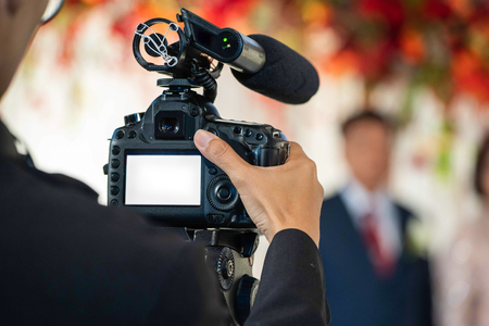 Female Videographer in backside are shooing and recording video in Wedding Event.の写真素材
