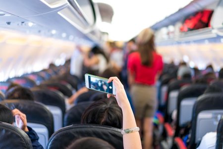 traveler take selfie photo from mobile phone in the airplane seat. Image from backside.の写真素材