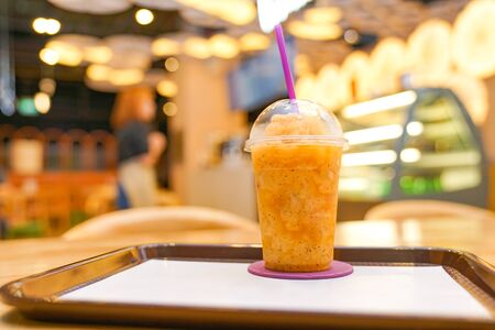 Passion fruit smoothie in plastic take away cup in the restaurant.の写真素材
