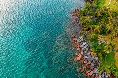 Rock in the sea beach from drone angle to the clearly sea water. It can see the sand behind the sea.