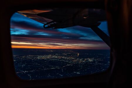 Twilight to Night from the jet plane view red orange blue sky with the light of Thailand city belowの写真素材