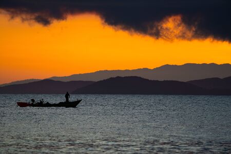Thailand sea in twilight time with Silhouette ship and fisherman in the seaの写真素材