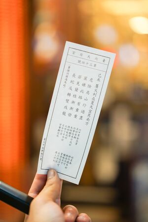 Taipei, TAIWAN - 2 Oct, 2017: The Seamsi (Paper fortune from drawing the stick in bamboo box) was held in male hand in Longshan Temple in Taipei, Taiwan.のeditorial素材