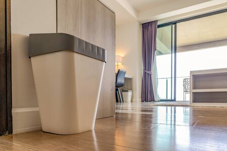 close up garbage rubbish trash plastic can with gray cover in the resort bedroom with the window...