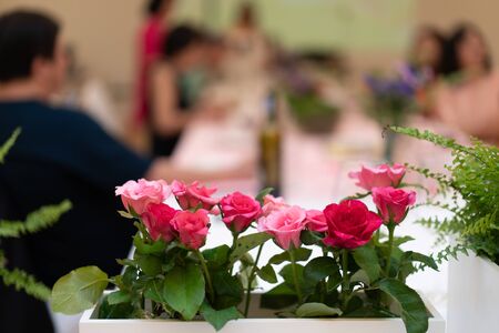 flowers decorate on the dinning long table in the luxury relax event with the blur social people behindの写真素材