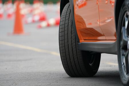 close up wheel of orange car on the road