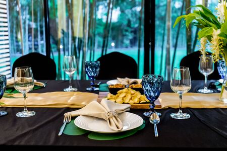 Luxury Lunch or Dinner set on the long table pattern with a black cover table with flower...