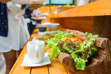 Mixed green red yellow and colourful vegetables slideed and arranged into bowl and wood basket...