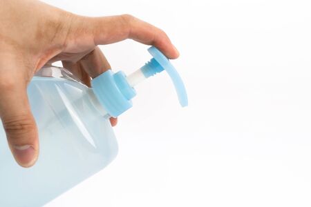 Asian mand hand holds a gel alcohol pump bottle and ready to pushes on it. It's an isolated object...
