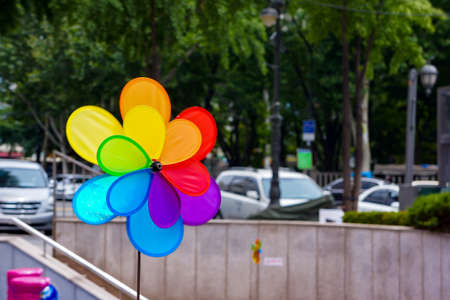 Colourful Wind turbine in the city on the road and a lot of car are driven on it.の写真素材