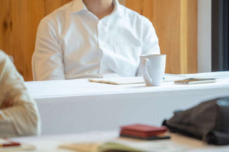 close up to seminar audience with their glass and gadget on the table.の写真素材