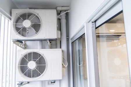 two air conditioning compressors are hung on wall.の写真素材