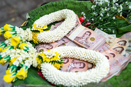 Thai Banknote 1000 Baht in Phan (tray with pedestal) with graland to make merit and to donate money to charity in Thai Traditional way.の写真素材