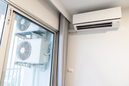two air conditioning compressors are hung on wall.の写真素材