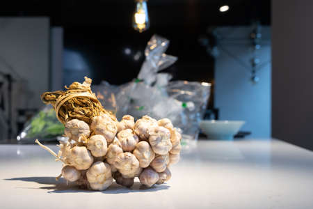 Garlic Bundle in studio light on the white marble surface table, prepare for a food demonstration behind.の写真素材