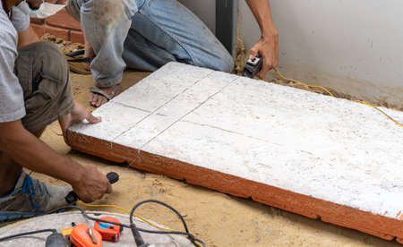 Two labour cut the Polyurethane Foam Brick Plate by Heat Wire tool for install in on the wall.の写真素材