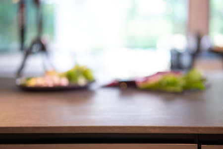 Stone granite Counter table in the kitchen with blur raw ingredient food background for a food product backdrop.の写真素材