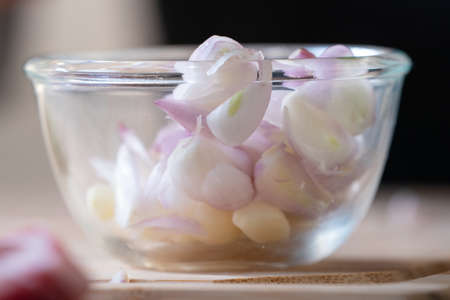 Sliced Shallot and Garlic is put and prepared in Glass Bowl, ready to cook for meal.
