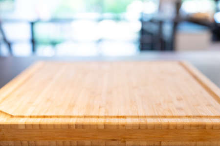wooden cutting board base on the table with perspective wood over blur light bokeh background for package and product content mockup banner and advertisment template.の写真素材