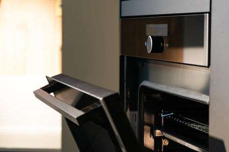 Modern minimal Oven building with wooden furniture in Kitchen with full green tree bokeh glass window beside for copy space advertising design.の写真素材