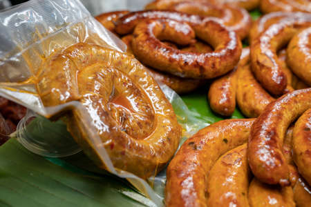 Wrapped packaging of Sai Aua, Northern Thailand Spicy Sausage, a famous Traditional Local saurage cooked with curry and herb at shop and ready for sales.の写真素材