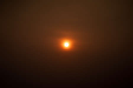 close up to the sun in center of minimal image in runrise time without any cloud around it.