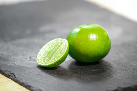 close up fresh lime, lemone in studio light on black stone plate in the kitchen.の写真素材