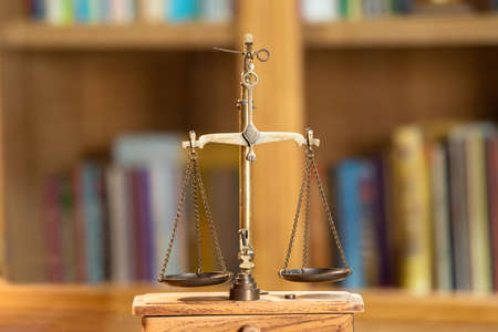 Close up to Golden vintage Scale Symbolic of Legal and Law section is standing on wood base in front...