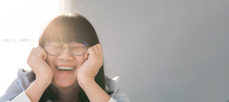 Banner Artwork Panorama close up to Asian HAPPY GLASSES girl face in  the bedroom with sunlight from the window behind her.の写真素材