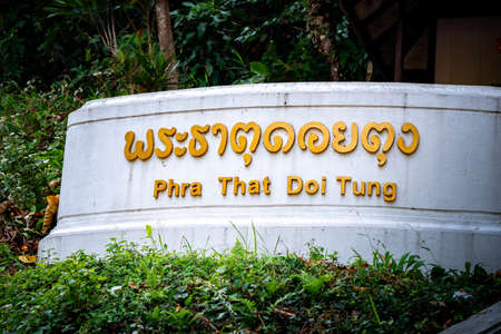 Gold text Banner in front of Stair, Thai Language mean Phra That Doi Tung, it's the name of the...