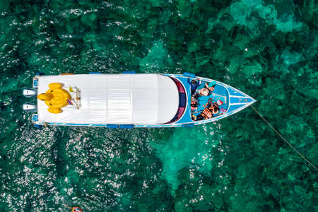 Topview of Boat Travel Snorkelling Trip is waiting for Tourists Swim Snorkel on surface sea.