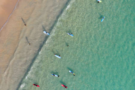 A Lot of People play and surf on Kata beach from Drone top view, a beautiful shot represent the...