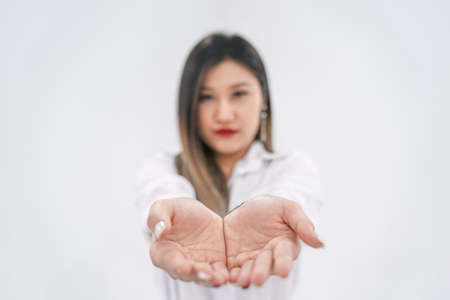 Empty thing in young Asian womanâs two hands are raised up in front of camera for any presenting products or wording advertisements.の写真素材