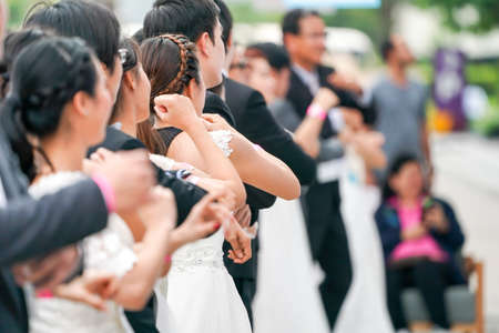 Various brides and grooms are warming up at starting line in preparation for race in order to win and receive payment for their ideal wedding.の写真素材