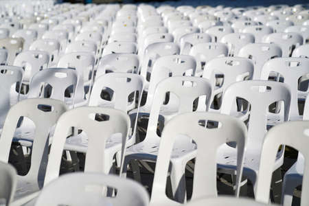 Many white plastic chairs were set up in a square area with the row and column for outdoor concerts or open air events.の写真素材