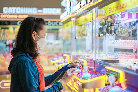 Bangkok, Thailand - 11 Feb 2022, Asian Woman was playing and having fun with the claw machine, or...