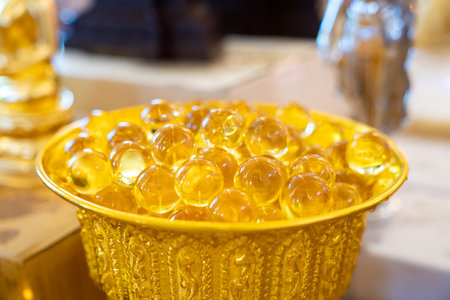 Clear transparence round glass acrylic plastic bubbles with light reflex inside in a yellow gold plate.の写真素材