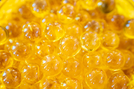 Clear transparence round glass acrylic plastic bubbles with light reflex inside in a yellow gold plate.の写真素材