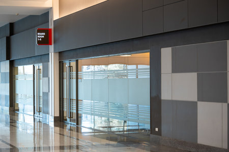 Large gray conference room with large glass walls and doors in an elegant building.