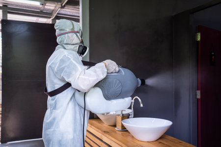 Professional technical man in prevention suit with his sterilizing machine and disinfecting water...